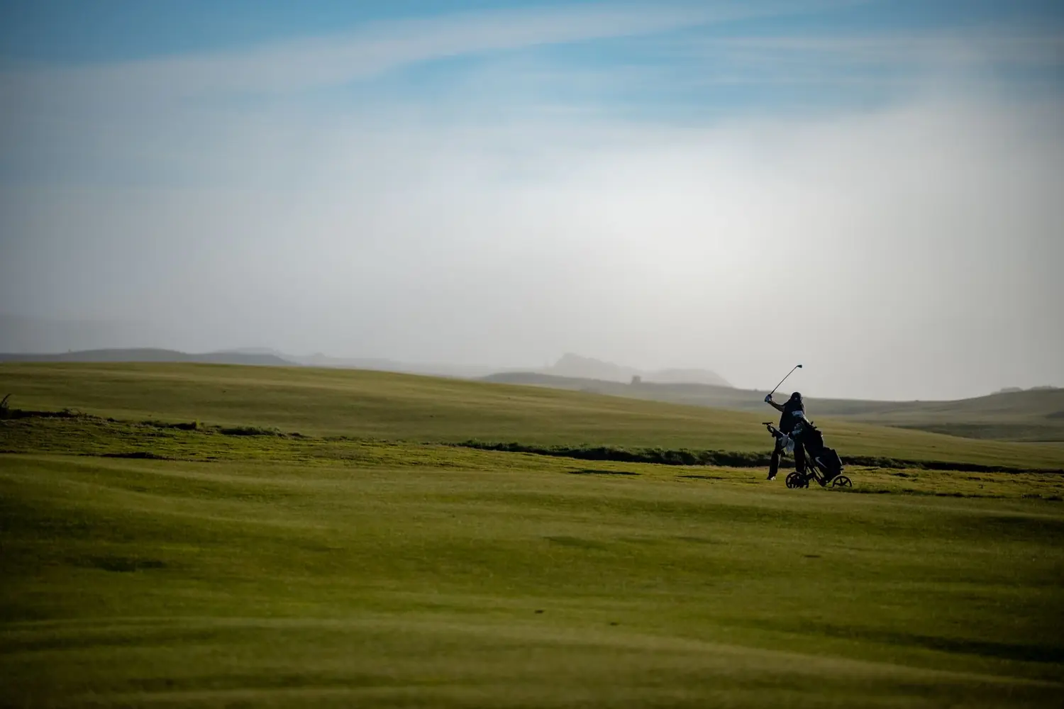 A wide, misty links course at dawn